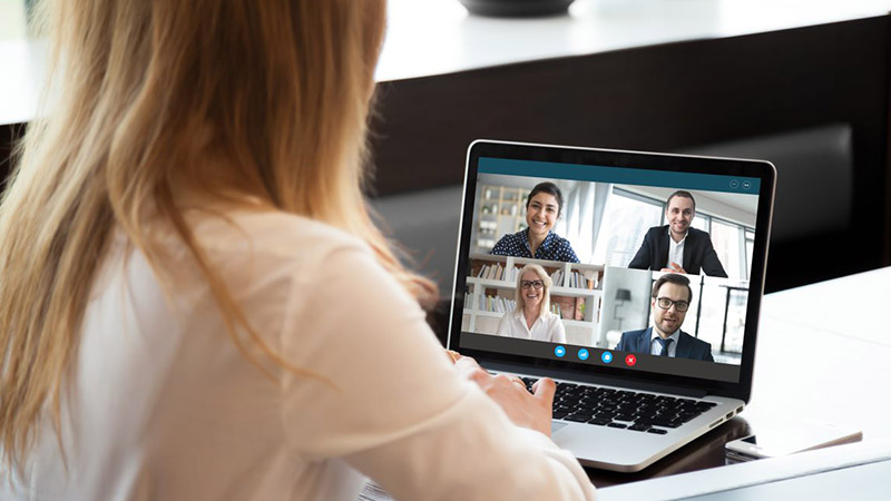 A woman at a computer, participating in a virtual meeting