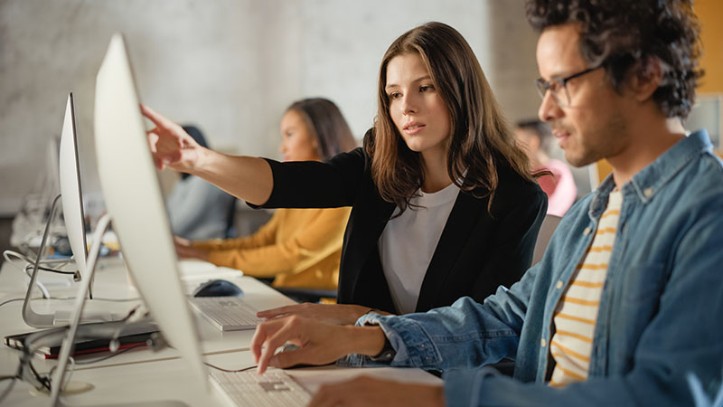 A group of teachers working on a computer