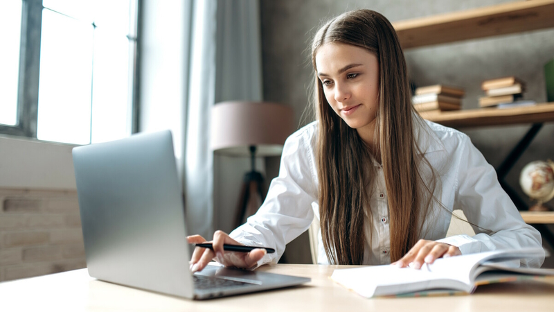 Student with a book and a computer