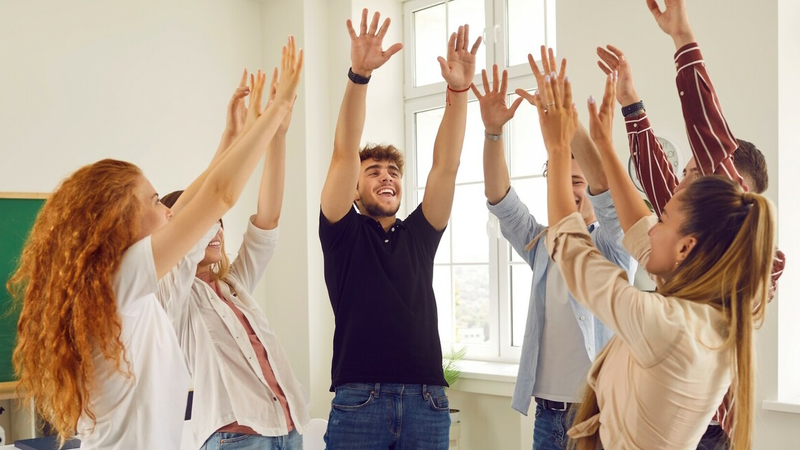 Students with their arms raised