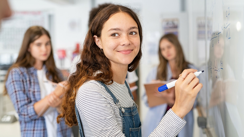 Estudiante escribiendo en un pizarrón