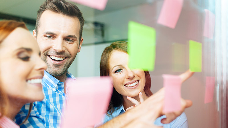 Grupo de personas trabajando en equipo, con papeles de colores